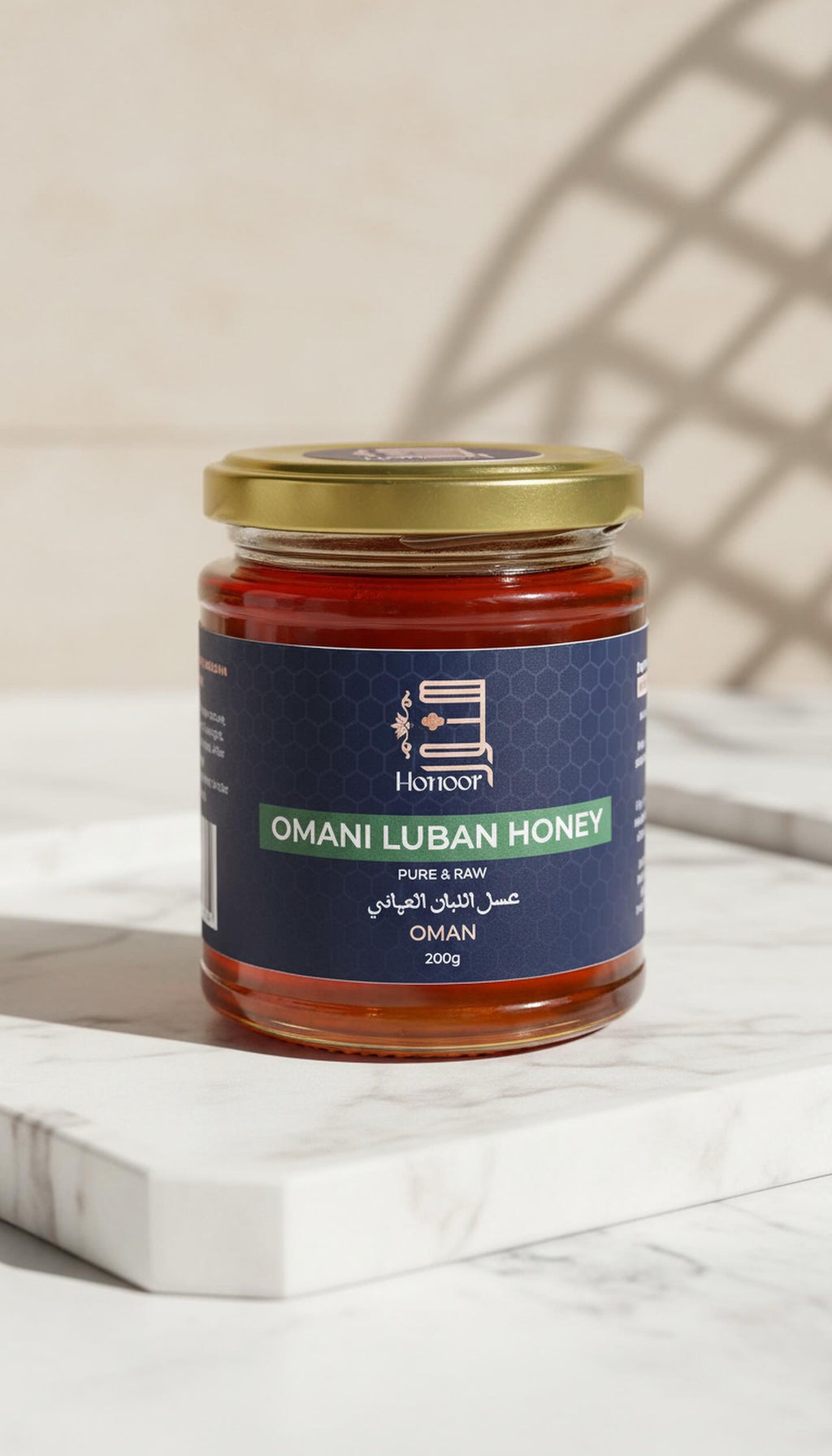 Jar of Omani Luban Honey on a marble surface with a neutral background

