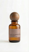 Brown glass bottle with wooden cap on a white background

