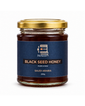 A glass jar of Honoor Black Seed Honey with a gold metal lid and a dark blue label, set against a plain white background.

