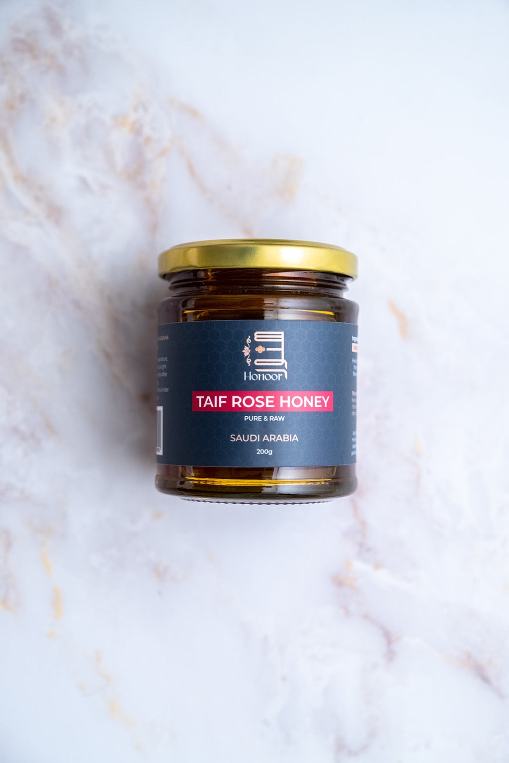 Jar of Taif Rose Honey on a marble surface

