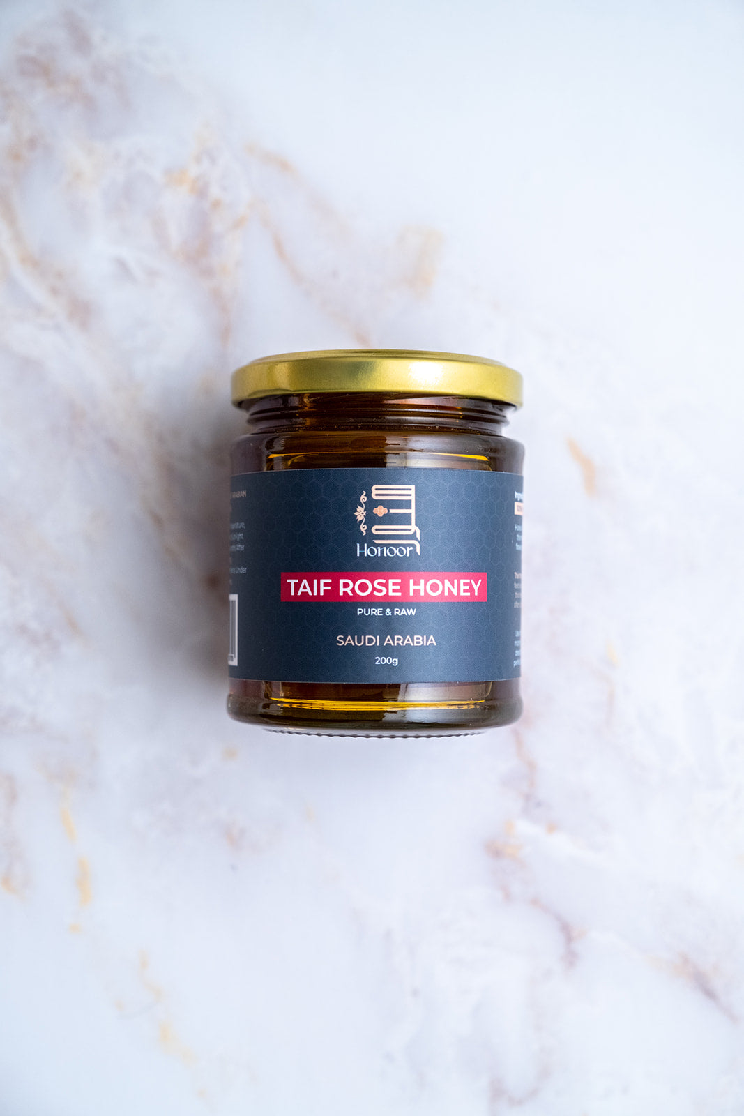Jar of Taif Rose Honey on a marble surface

