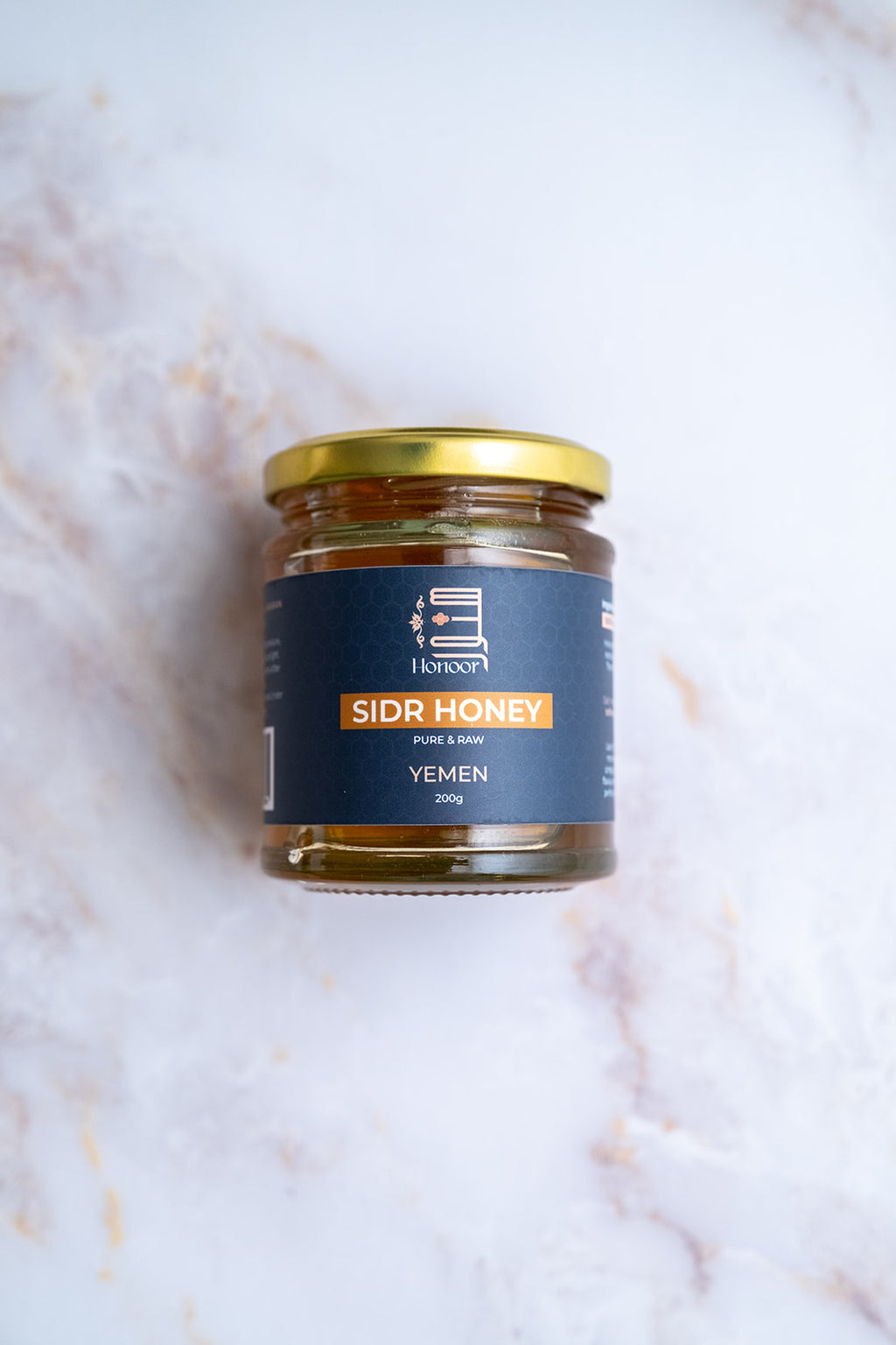 Jar of Sidr Honey from Yemen on a textured white background

