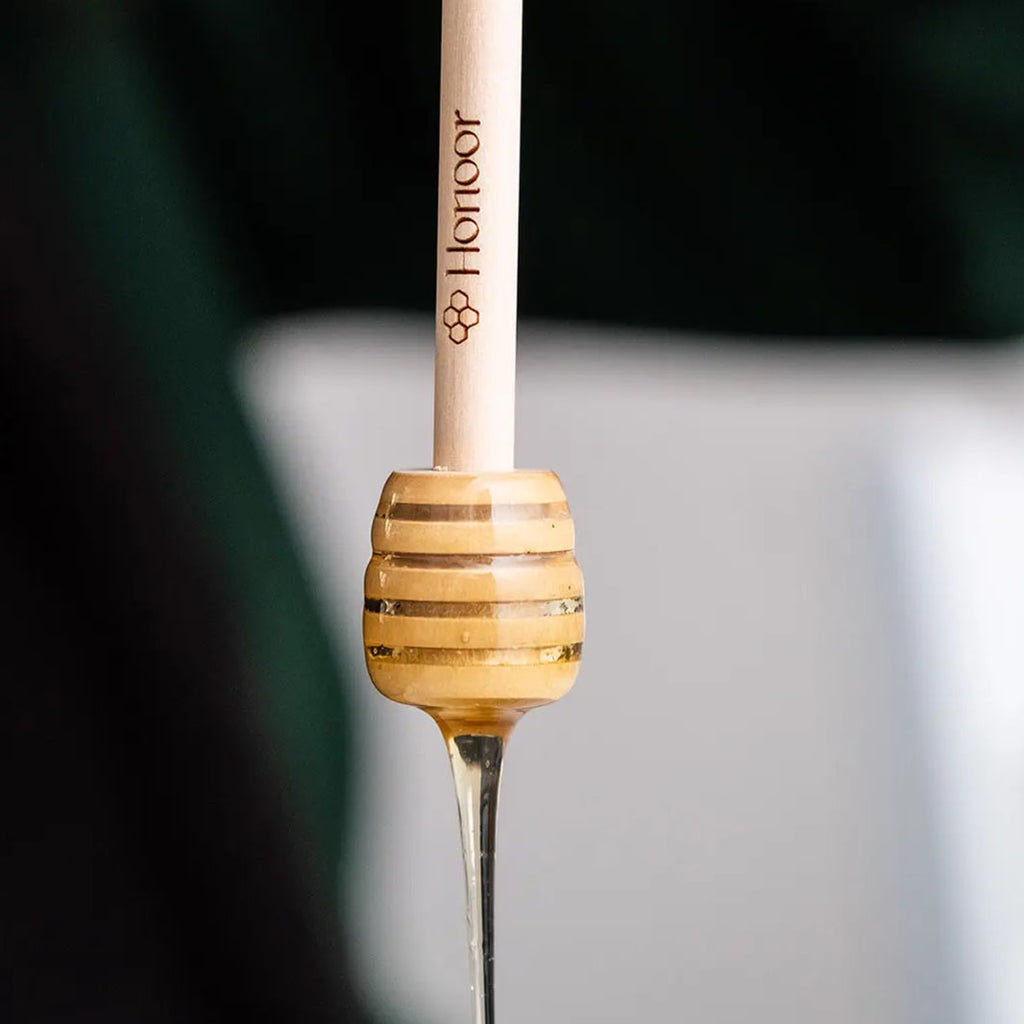 Close-up of a fishing rod with a wooden handle and visible brand logo.

