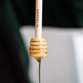 Close-up of a fishing rod with a wooden handle and visible brand logo.

