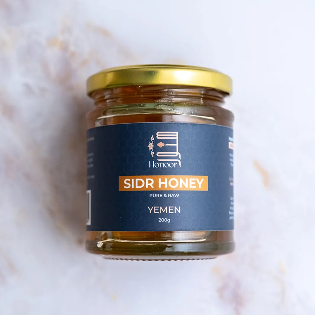 Jar of Sidr Honey with a blue label on a light background

