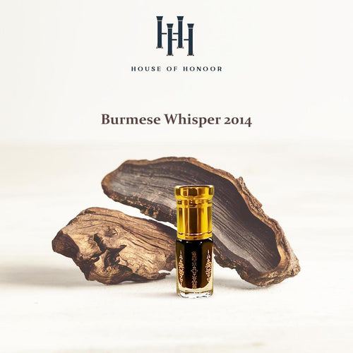 Perfume bottle labeled 'Burmese Whisper 2014' by House of Honoor on a wooden background

