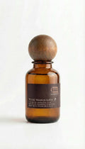 Amber glass bottle with wooden cap on a white background

