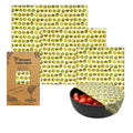 Beeswax food wrap with kiwi pattern, packaging, and a bowl of tomatoes.

